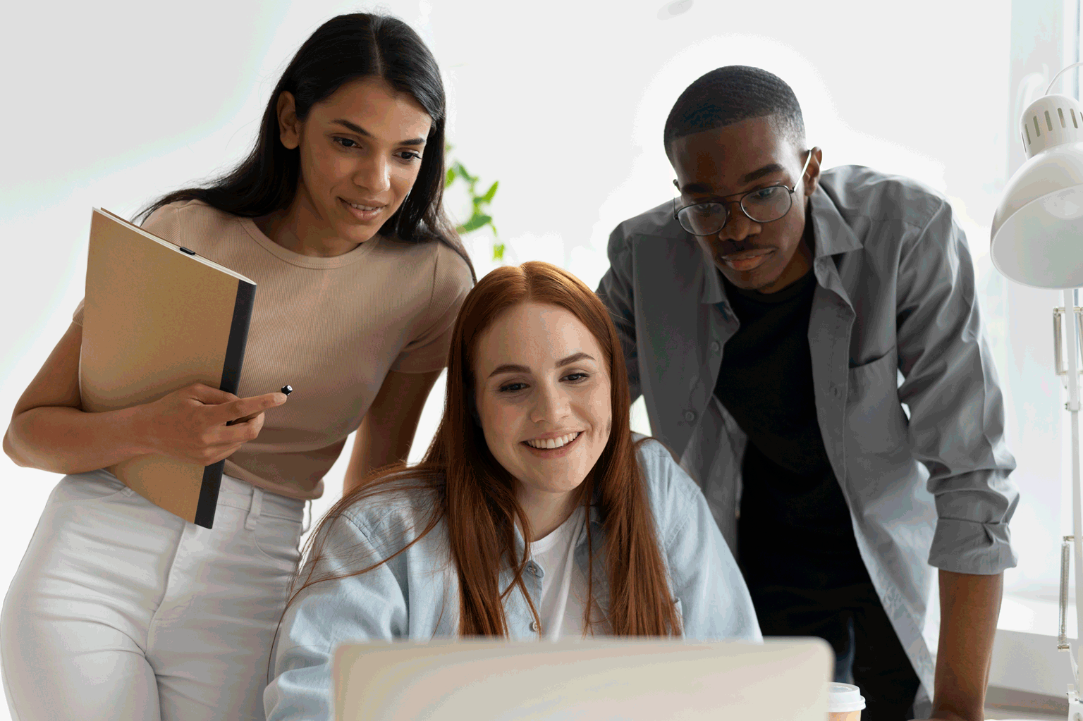 Na imagem 3 jovens estão conversando de frente do computador sobre Quais são as habilidades profissionais essenciais para se destacar em 2024