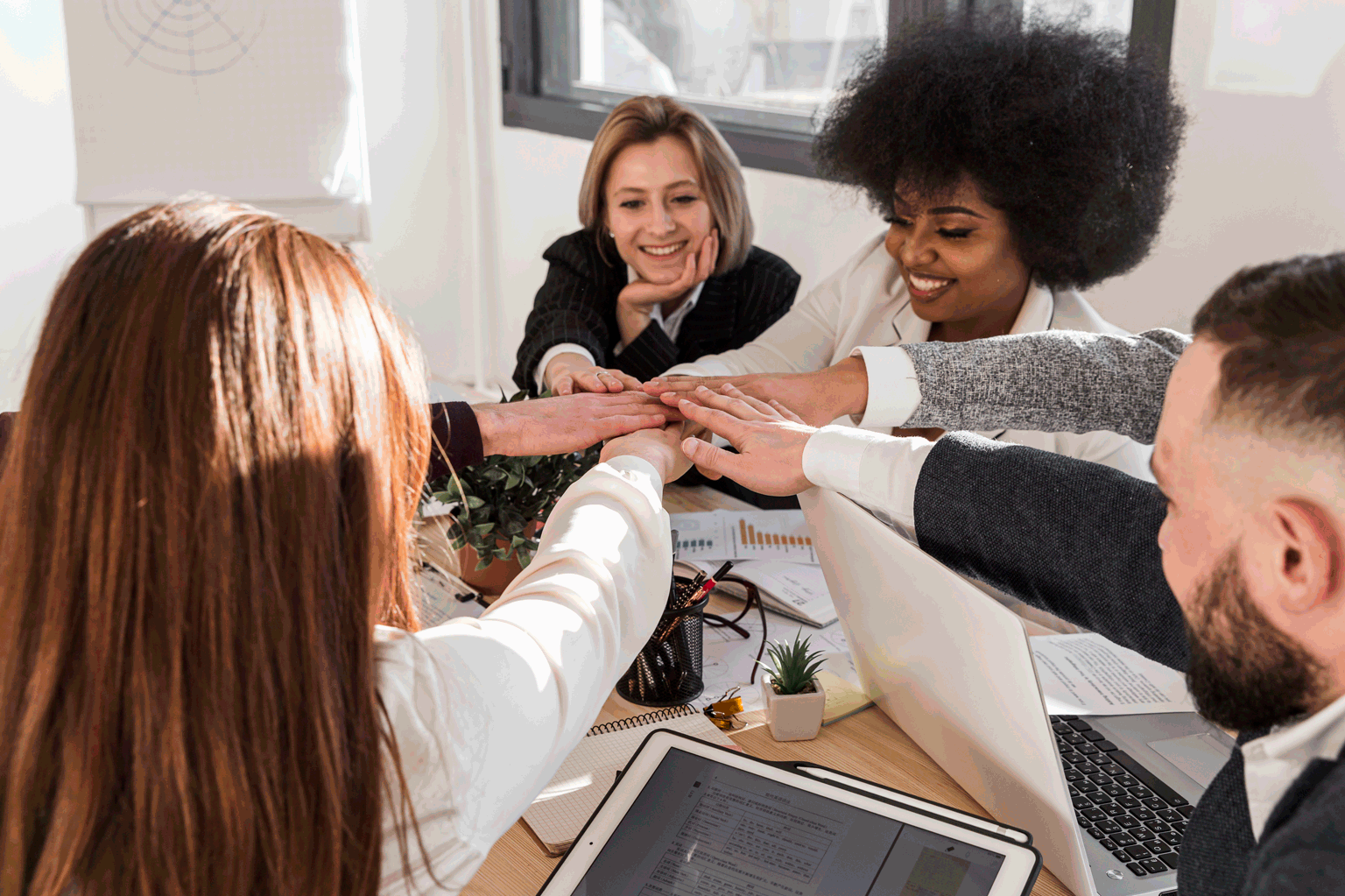 Jovens representantes da diversidade sentados dando as mãos, em uma imagem clara da representação do Jovem Aprendiz na Responsabilidade Social Corporativa