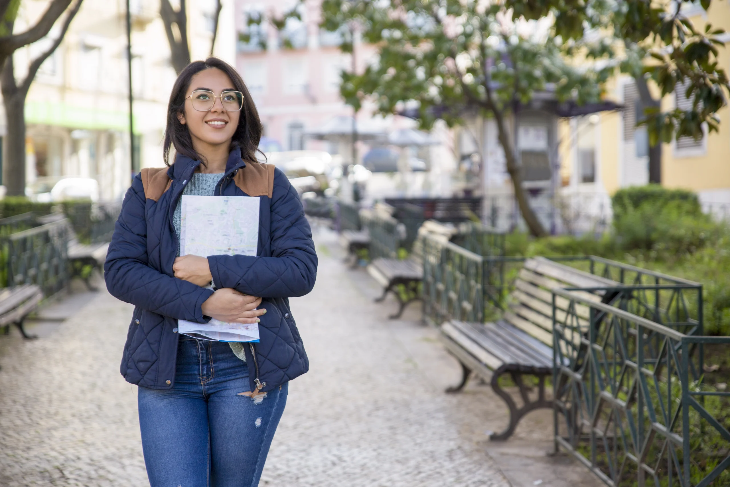 Jovem aprendiz caminhando sorridente, segurando seu caderno, enquanto pensa no novo salário mínimo de 2025