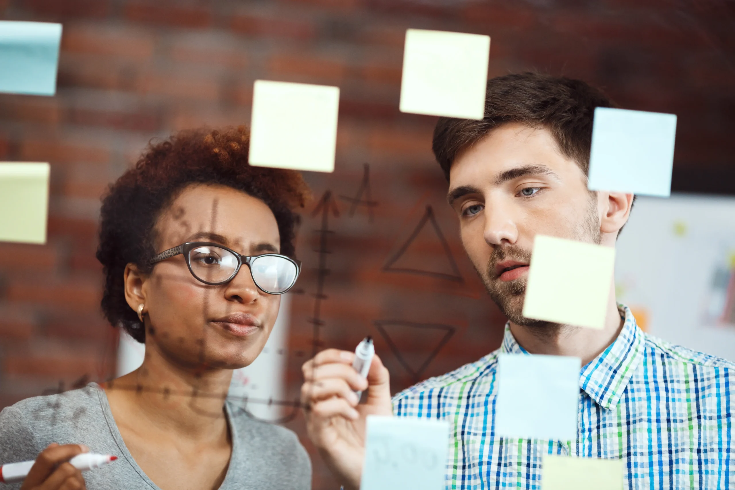 Descrição da imagem: Imagem mostra uma jovem aprendiz participando de reunião com colegas, representando habilidades comportamentais como comunicação e trabalho em equipe.