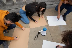 Três profissionais demonstram engajamento e colaboração em uma reunião descontraída, refletindo um ambiente de trabalho saudável, produtivo e acolhedor.
