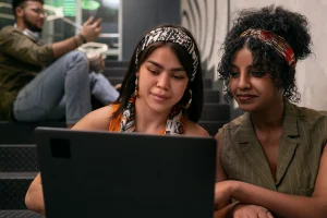 Jovem aprendiz em ambiente de trabalho acompanhado por tutora do ISBET durante atividade do programa de aprendizagem.