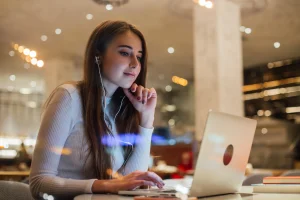 Jovem utilizando Inteligência Artificial no computador para melhorar currículo e se preparar para conseguir emprego