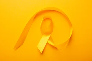 Profissional de saúde segurando laço amarelo da campanha Julho Amarelo