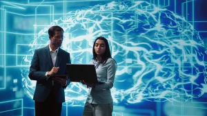 Jovens profissionais colaborando em um ambiente moderno enquanto utilizam Inteligência Artificial como apoio às atividades de trabalho.