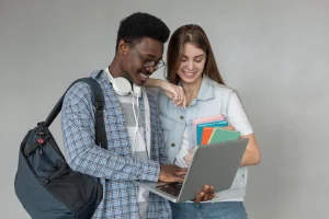 Estudantes reunidos em uma biblioteca estudando e planejando o futuro profissional com notebooks e materiais de apoio.