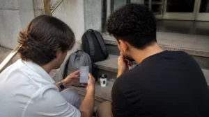 Jovens aprendizes olhando o perfil no LinkedIn pelo celular