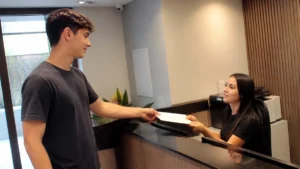 Ética e postura profissional no primeiro emprego: jovem entrega um documento na recepção da empresa